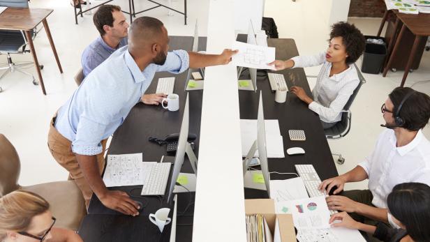 Man and woman with documents in an office, smiling Forscher fordern neue Büro-Konzepte