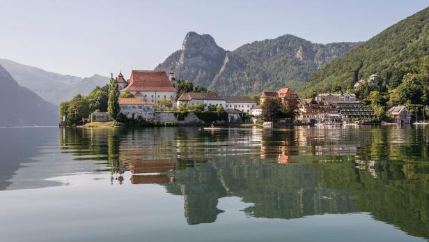 Tiefer See und hohe Berge: Das Kloster Traunkirchen mit dem Seehotel Das Traunsee (rechts).