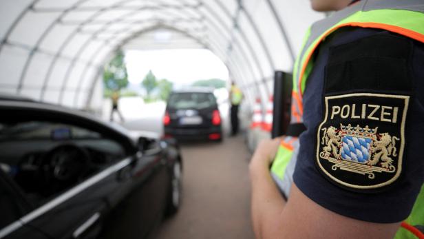 FILE PHOTO: A German police officer controls a car at a checkpoint between the Austrian and German border in Kiefersfelden